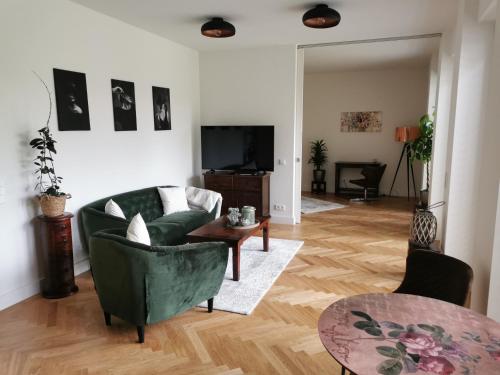 un salon avec un canapé vert et une table dans l'établissement exklusives Studioapartment - in traumhafter Lage direkt am Halensee, à Berlin