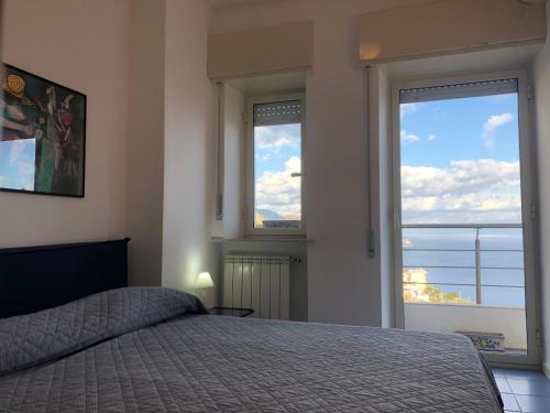 una camera con un letto e due grandi finestre di TAORMINA CENTER APARTMENT with sea view a Taormina