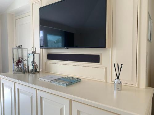 a white counter with a television on a wall at White House Luxury Hospitality in Olbia