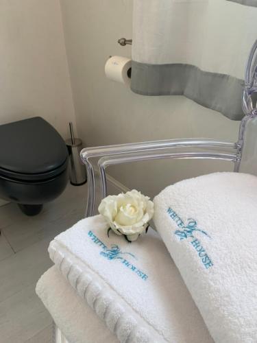 a towel rack with towels and a flower on it at White House Luxury Hospitality in Olbia