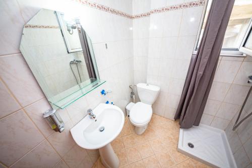 uma casa de banho com um WC, um lavatório e um chuveiro em Apartments Cikuli em Sarandë