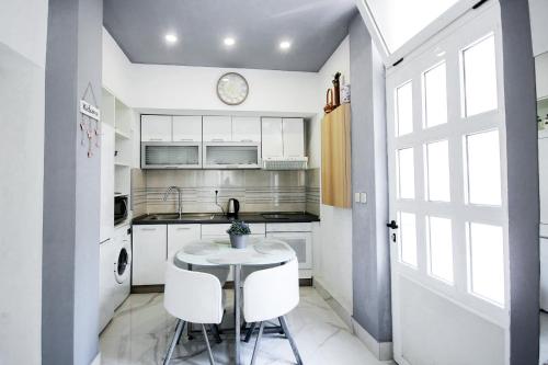 a kitchen with white cabinets and a table and chairs at Villa Norah in Podgora