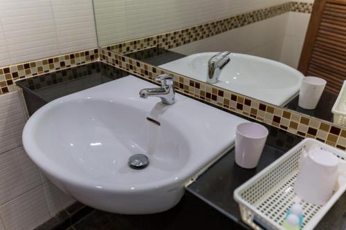 a white sink in a bathroom with a mirror at Baan Suan Khun Ta and Golf Resort in Ubon Ratchathani