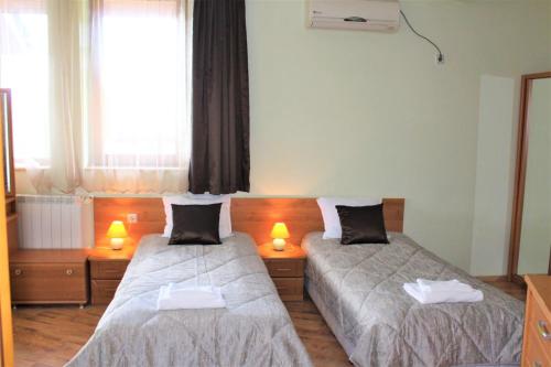 two beds in a room with two lamps on them at Guest House Brezata - Betula in Glavatartsi