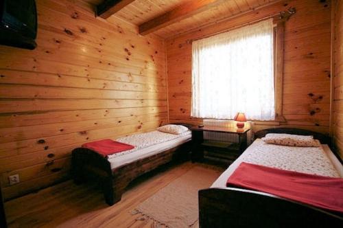 a room with two beds in a log cabin at Noclegi Gaja in Święta Katarzyna