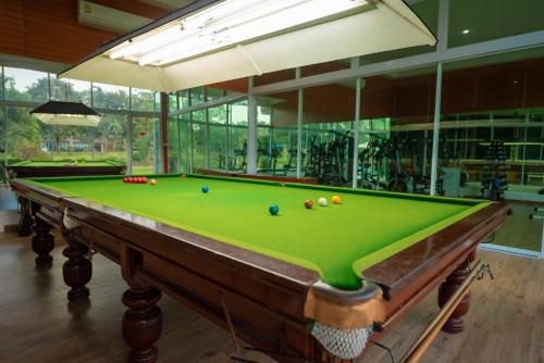 a pool table with balls on it in a room at Baan Suan Khun Ta and Golf Resort in Ubon Ratchathani