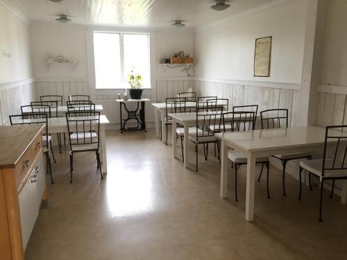 a dining room with tables and chairs and a window at Kustnära Vandrarhem in Hamburgsund