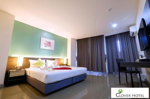 a hotel room with a bed and a television at Clover Hotel Hatyai in Hat Yai