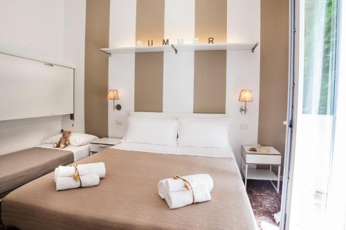 a hotel room with two beds with towels at De La Ville Hotel in Cattolica