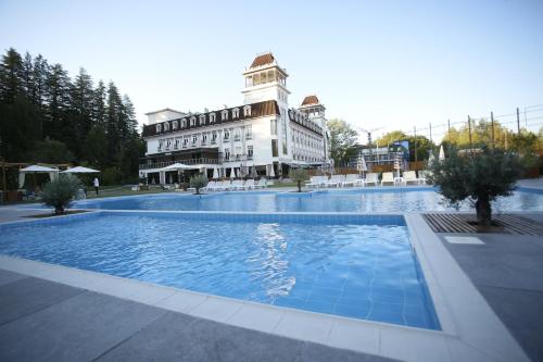 a building with a swimming pool in front of a building at Tskaltubo Plaza Hotel in Tsqaltubo