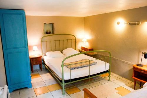 um quarto com uma cama com uma estrutura de metal verde em La Tanière des druides em Luzech