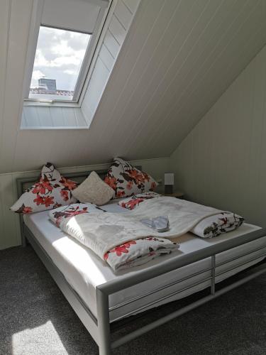 Bett in einem Zimmer mit Fenster in der Unterkunft Apartments Margaretenhof in Wilhelmshaven