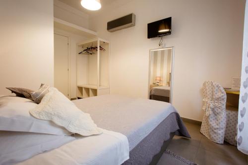 1 dormitorio con 1 cama blanca y 1 silla en Affittacamere Le Camere Nel Corso - ADULTS ONLY, en La Spezia