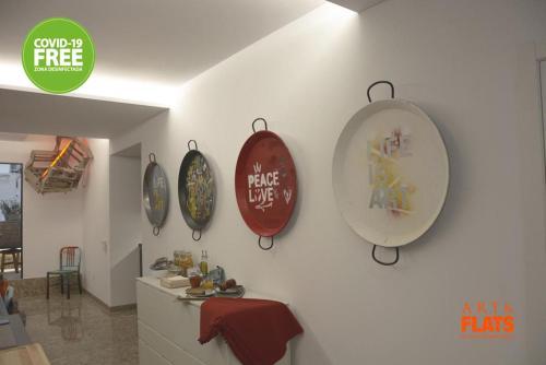 a wall with four plates hanging on a wall at Art&Flats Hostel in Valencia
