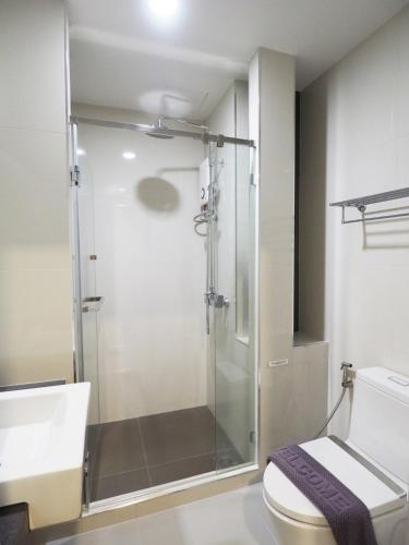 a bathroom with a shower and a toilet at Clover Hotel Hatyai in Hat Yai