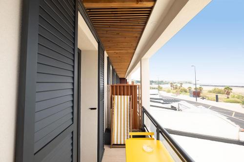 a yellow bench on the balcony of a building at Hôtel de la Plage in Sète