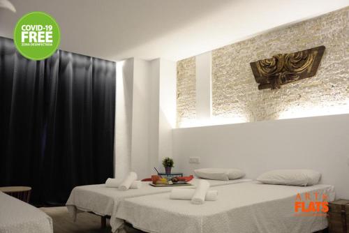 a bedroom with a large bed with white sheets at Art&Flats Hostel in Valencia