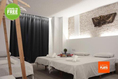 a room with two beds and a sign that says give me free milk fats at Art&Flats Hostel in Valencia