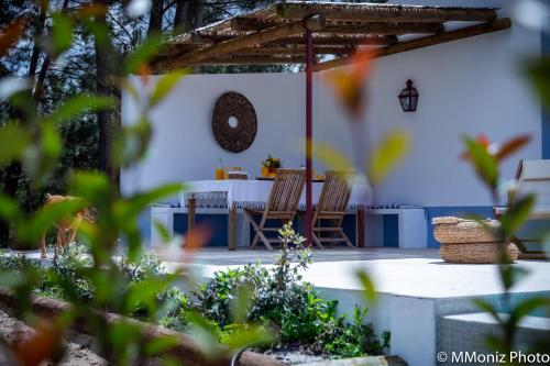 a patio with a table and chairs in a yard at Casas da Horta in Alcácer do Sal