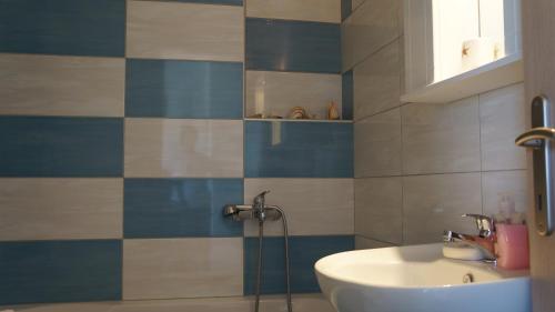a bathroom with a sink and blue and white tiles at 4S Beach Superior Apartments in Stalís