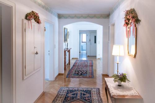 a hallway with rugs on the floor and a table and a hallway with two at Landhaus zu Kürenberg in Bergham