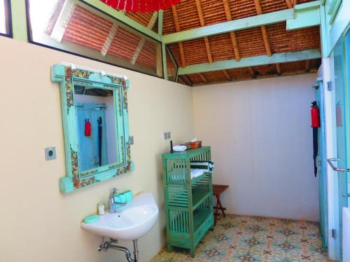 a bathroom with a sink and a mirror at Manggis Garden Dive Resort in Candidasa