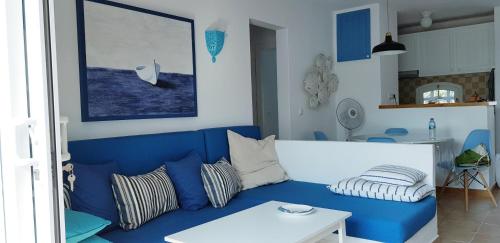 sala de estar con sofá azul y mesa en Els Vents, tu apartamento junto al mar en Son Parc, en Son Parc