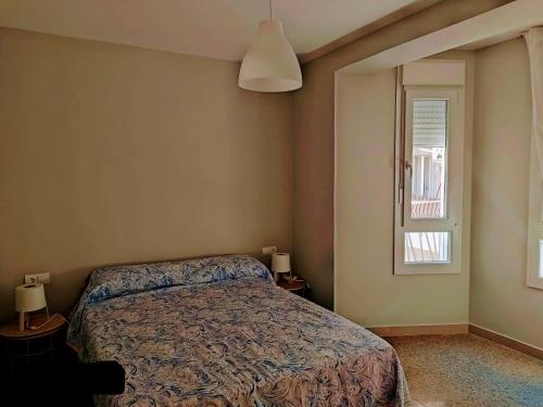 a bedroom with a bed and a window at El Verd in L'Ametlla de Mar
