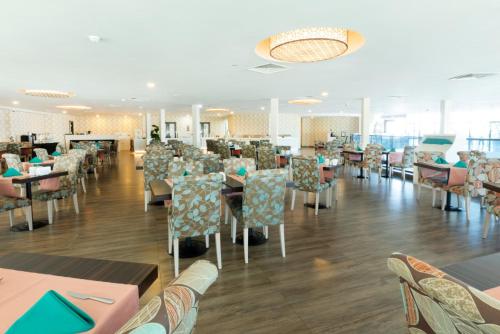 a dining room with chairs and tables and tablesktop at King Sky Tower Hotel in Batumi