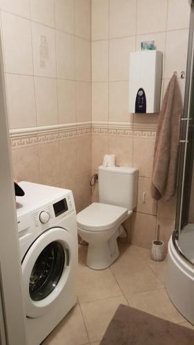 a bathroom with a toilet and a washing machine at Morski Apartament 2 in Ustka