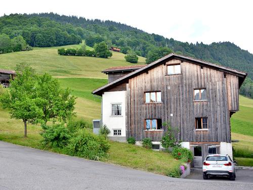 a large wooden house with a car parked in front of it at Latura - 3.5 Zimmerwohnung für 4 Personen, 80m2 in Buchen