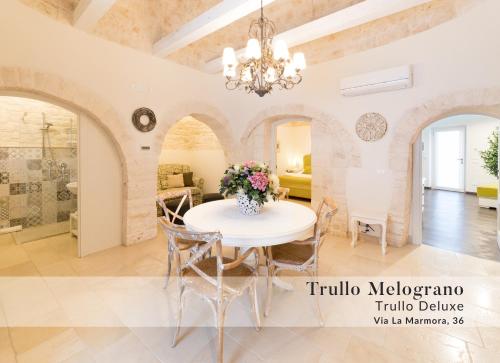 una sala da pranzo con tavolo e sedie bianchi di Dimore nel Tempo ad Alberobello