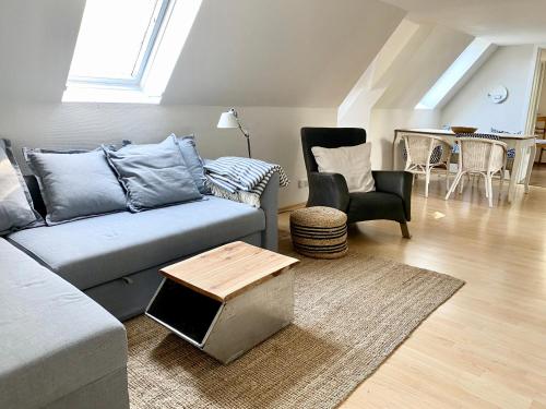 a living room with a couch and a table and chairs at Ferienwohnung Hochdorfer Garten in Tating