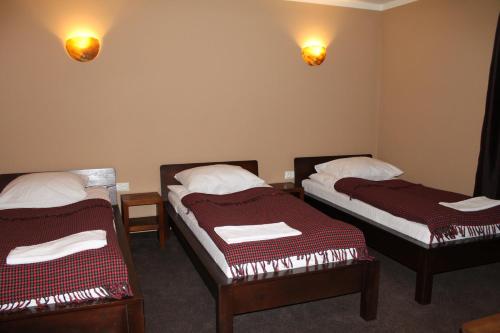 a room with two beds and two lights on the wall at Dobry Czas in Sandomierz
