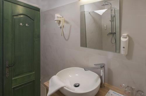 a bathroom with a white sink and a green door at Hotel Villa Diana in Split