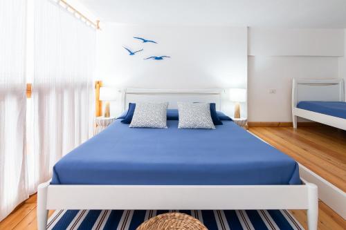 1 dormitorio con 1 cama azul y 2 pájaros en la pared en Casa Bolina, en Marina di Campo