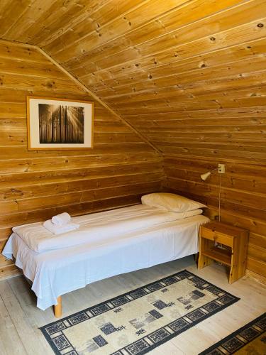 a bedroom with a bed in a wooden cabin at Mo Laksegard in Sand