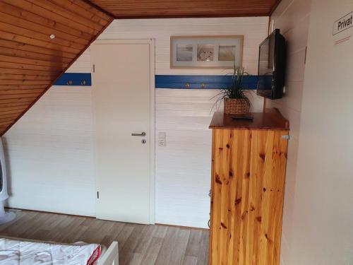a garage with a door and a tv in a room at Ferienhäuser Seemannsgarn in Friedrichskoog-Spitz