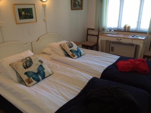 two beds with pillows on them in a bedroom at Hotell Turistgården i Simrishamn in Simrishamn