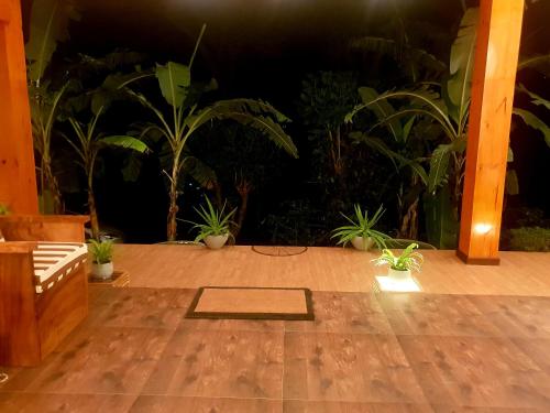 a patio with potted plants and a wooden floor at Leisure Dream Inn in Ella