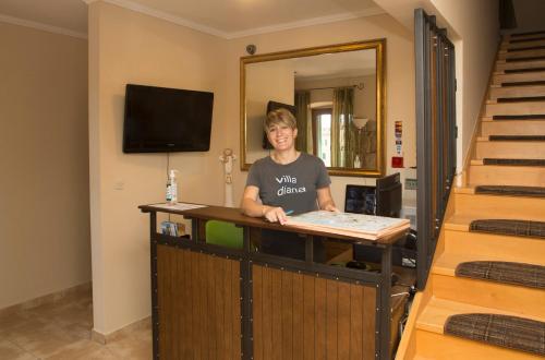 
a woman sitting at a desk with a laptop at Hotel Villa Diana in Split
