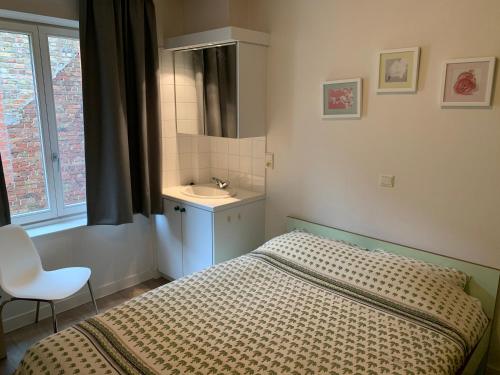 a small bedroom with a bed and a sink at Koksijde App Zeelaan B3 in Koksijde