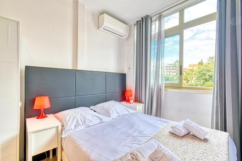 une chambre avec un grand lit et une fenêtre dans l'établissement Beautiful modern apartment in the heart of Cannes, à Cannes