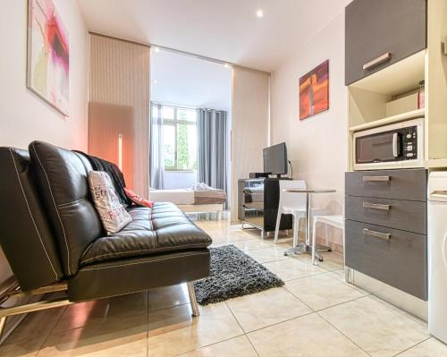 un salon avec un canapé en cuir et une table dans l'établissement Beautiful modern apartment in the heart of Cannes, à Cannes
