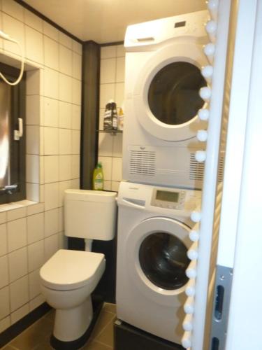 a bathroom with a toilet and a washing machine at Ferienwohnung Jakob in Bremerhaven