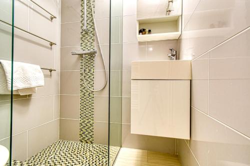 une salle de bain avec une douche avec une porte vitrée dans l'établissement Beautiful and cozy apartment in the heart of Cannes, à Cannes