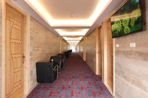 um corredor com uma fila de cadeiras num edifício em Tzukim Desert Traveler's Hotel - מלון צוקים em Mitzpe Ramon