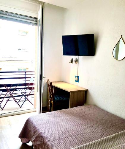a bedroom with a bed and a desk and a window at Hôtel Colisée-Verdun Centre Gare Saint-Roch in Montpellier