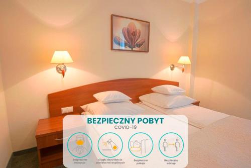 a hotel room with a bed and a lamp at Arena Hotel Spa & Wellness in Tychy