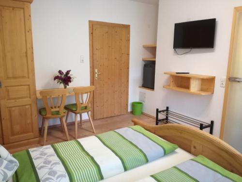 1 dormitorio con cama, mesa y TV en Bio Bauernhof Moas, en Lunz am See